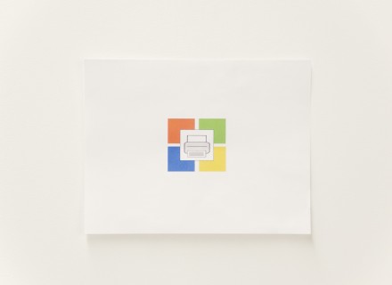 Photo from an overhead angle of a printer piece of paper with a windows icon and a printer icon on it.